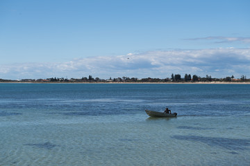 Angler fährt mit seinem Boot von rechts nach links zum nächsten Angelpunkt