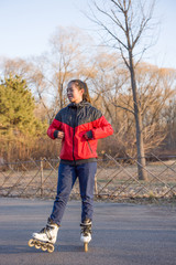 Portrait of roller skating sporty girl in park. Woman roller skating sport activity.