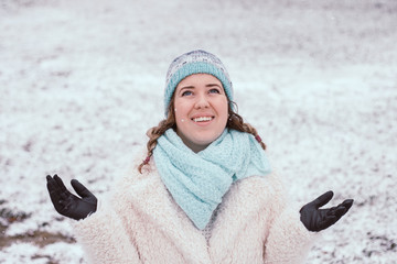Smiling young woman in snowing outdoor.