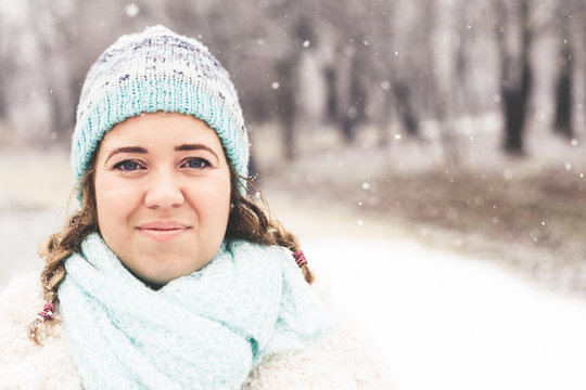 Smiling young woman in snowing outdoor.