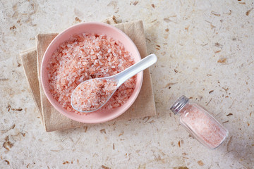 Pink Himalayan salt in the small pink bowl on marble surface.