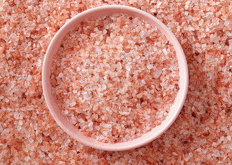 Pink Himalayan salt in the small pink bowl. A small pink bowl full of salt crystals.