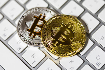 two coins of bitcoin on white laptop white keyboard close up