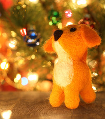 Symbol of new years 2018 yellow dog. Bolt. New years greetings background. Fancy handmade toy from wool on bokeh Christmas background. Copyspace for congratulations.