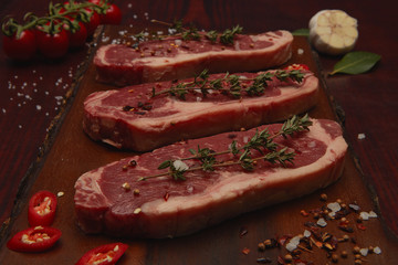 Beef steaks on cutting board .