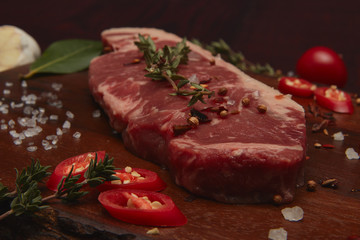 Beef steaks on cutting board .