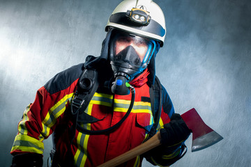 Feuerwehrmann unter Atemschutz mit Feuerwehr Axt im Einsatz