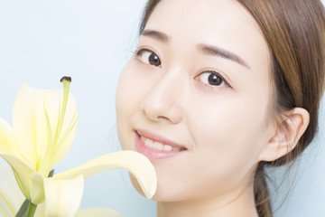 Portrait beauty woman face with yellow lily flower, closeup.