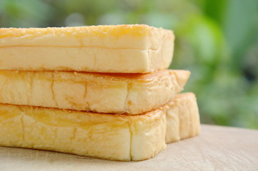 baked cheese bread slice on wooden chopblock