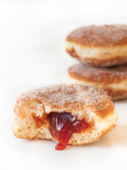 German fried donut, so called Krapfen, Berliner or Pfannkuchen, filled with rose hip jam and dusted...