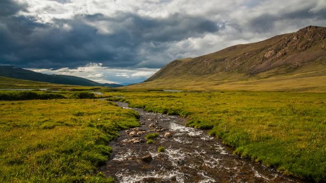 Dramatic sky over mountain river. Timelapse