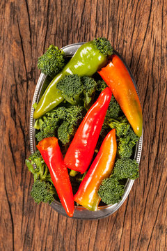 High angle view of fresh red pepperoni  frigitelli and broccoli on a wooden table.Vegan food
