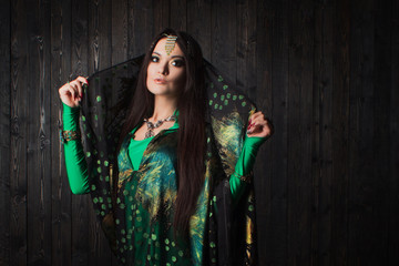 Beautiful girl in green dress dancing Oriental dance