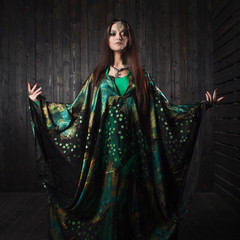 Beautiful girl in green dress dancing Oriental dance