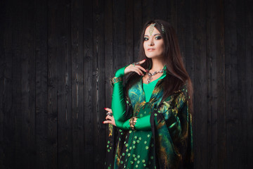 Fototapeta premium Beautiful girl in green dress dancing Oriental dance