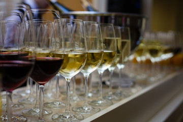 rows of wine glasses with red and white wine on a buffet table