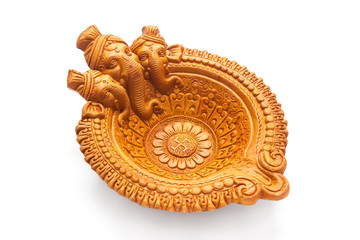 A beautiful Handmade Designer Clay Lamp having engraved Hindu God Ganpati on it, isolated on white background.