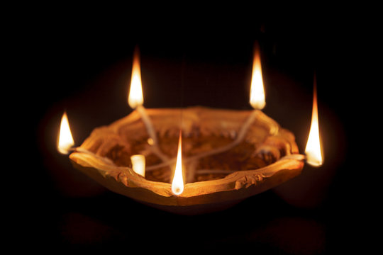 A declarative five facing Earthen Oil Lamp or Diya on dark background. Mainly used for decoration on Hindu festival Diwali.
