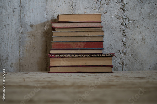 Pila Di Libri Antichi Su Tavolo Legno Grezzo E Muro Grezzo