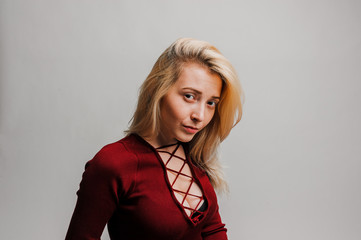 Fototapeta premium Young girl in a red dress on a white background