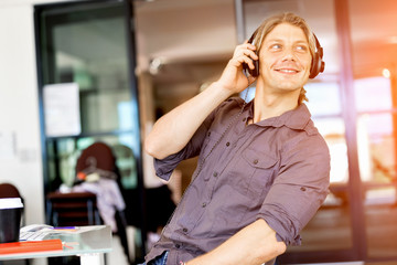 Young man in the office with headphones