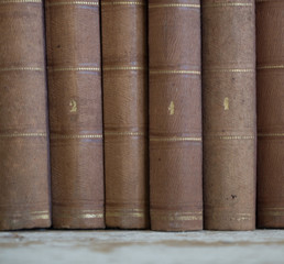 libri antichi vintage appoggiati a muro grezzo