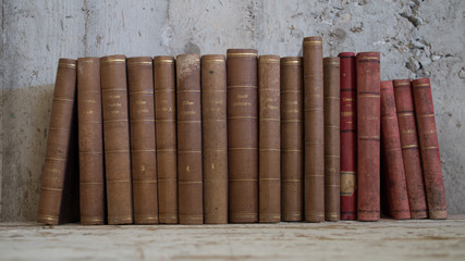 libri antichi vintage appoggiati a muro grezzo © benedetta