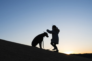 Fototapeta premium ドーベルマンと子供のシルエット