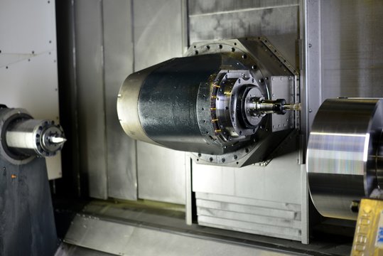 The 5-axis CNC machine while cutting the sample part of turbine.The spindle of 5 axis CNC machining center white cutting turbine sample part.