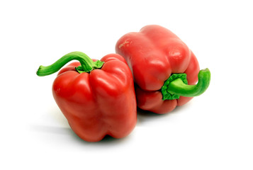 Still life with two whole red ripe bell peppers isolated on white background close up