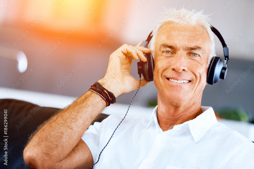 Wall mural handsome gray haired senior man with headphones