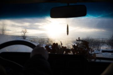 Fototapeta premium View from car window in winter snowy evening. Concept travel.