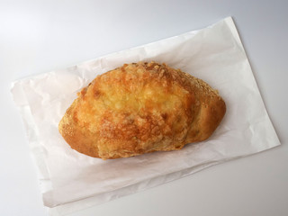Cheese bread on a paper bag, isolated on white.