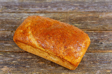 Fresh baked bread on cutting board, on wooden background