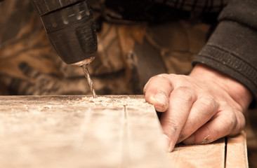 The master cuts the wood with a drill