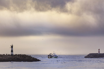 Fishing boat entering harbor after a day fishing 
