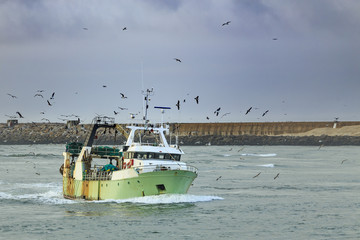 Fishing boat entering harbor after a day fishing 