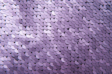 Texture of violet color sequins close-up macro abstract background. Fashionable expensive fabric...