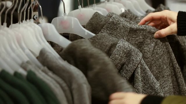 Woman choosing a sweatshirt at shop in shopping centre