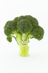 Closeup of fresh green broccoli with scared cartoon style face on white background