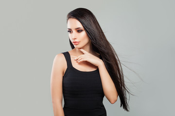 Young Woman Fashion Model with Long Healthy Hair and Natural Makeup on Gray Background