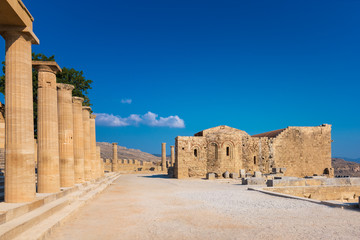 Columns of Portico and Church of St. John on the Acropolis of Lindos (Rhodes, Greece)