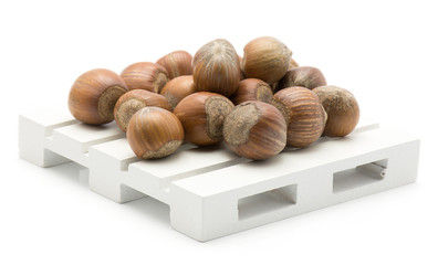 Hazelnuts unshelled on a pallet isolated on white background.