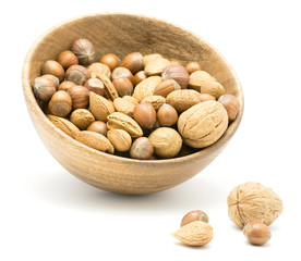 Nuts mix (walnut, hazelnut and almond) in a wooden bowl isolated on white background.