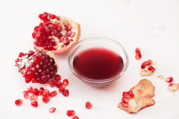 Syrup of pomegranate and broken pomegranate on white