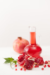 Pomegranate juice with pomegranate seeds on white