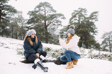 Friends taking photographs in snowy weather