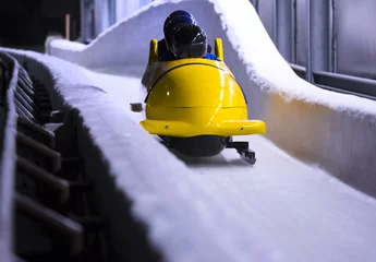 Foto auf Acrylglas Wintersport Bobschlitten, der in einem Eiskanal rast