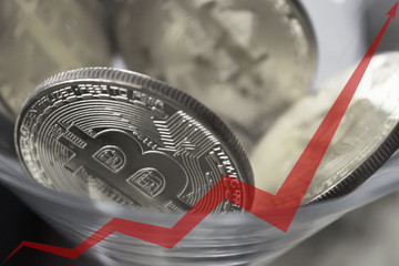 golden bitcoins in a cocktail glass, red arrow of the graph is directed upwards