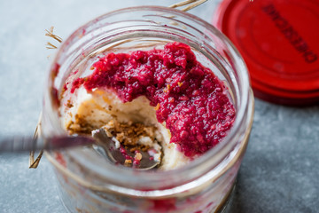 Forest Fruits Cheesecake in Jar with Spoon. / Unfinished Dessert.